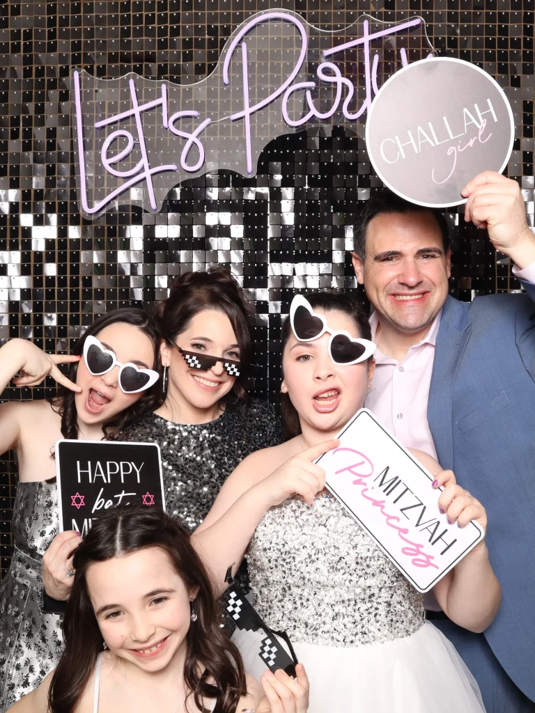 A group of people posing in front of a party backdrop.